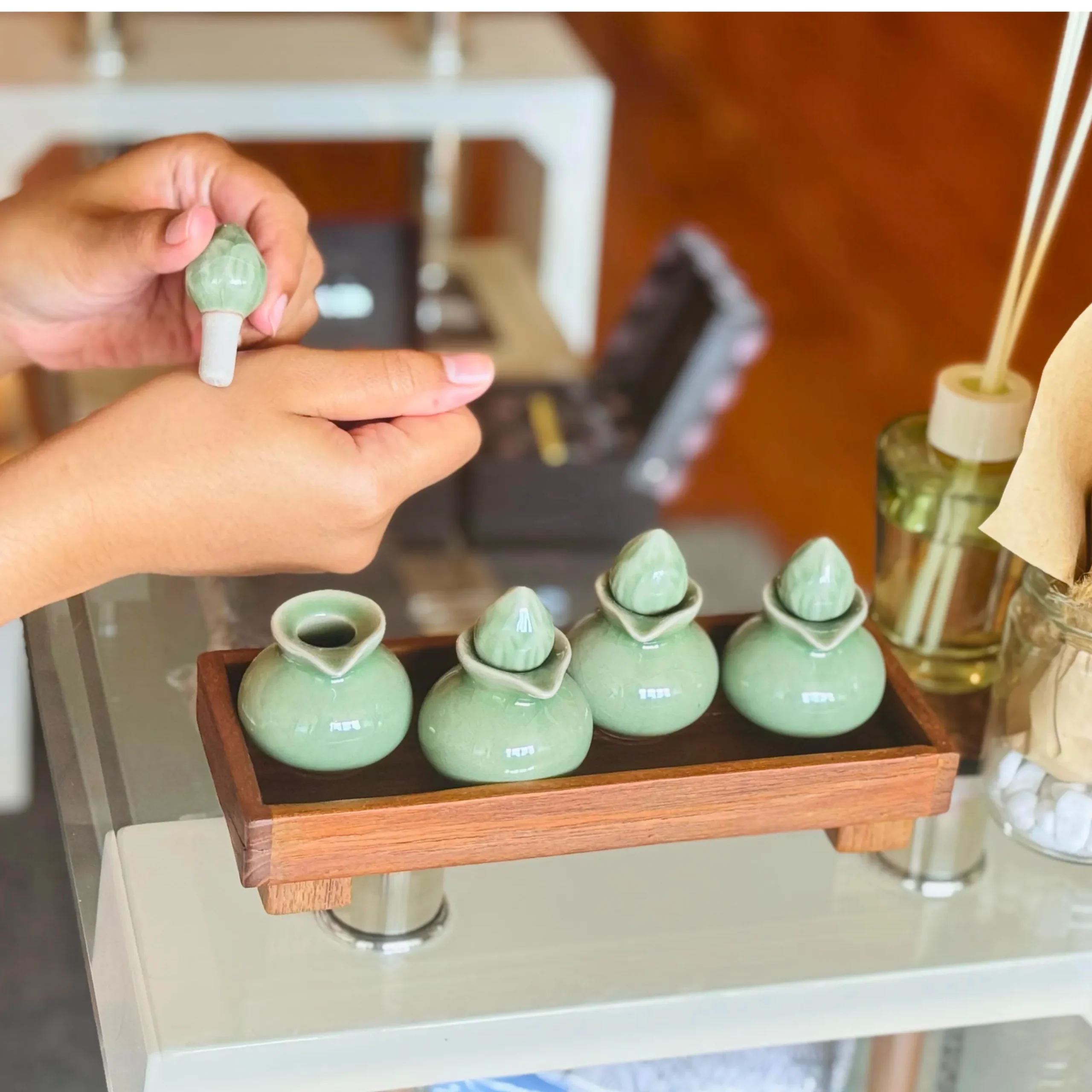 A photo of aromatherapy application porcelain drop tools and diffusers the woman is applying aromatherapy oil to hand