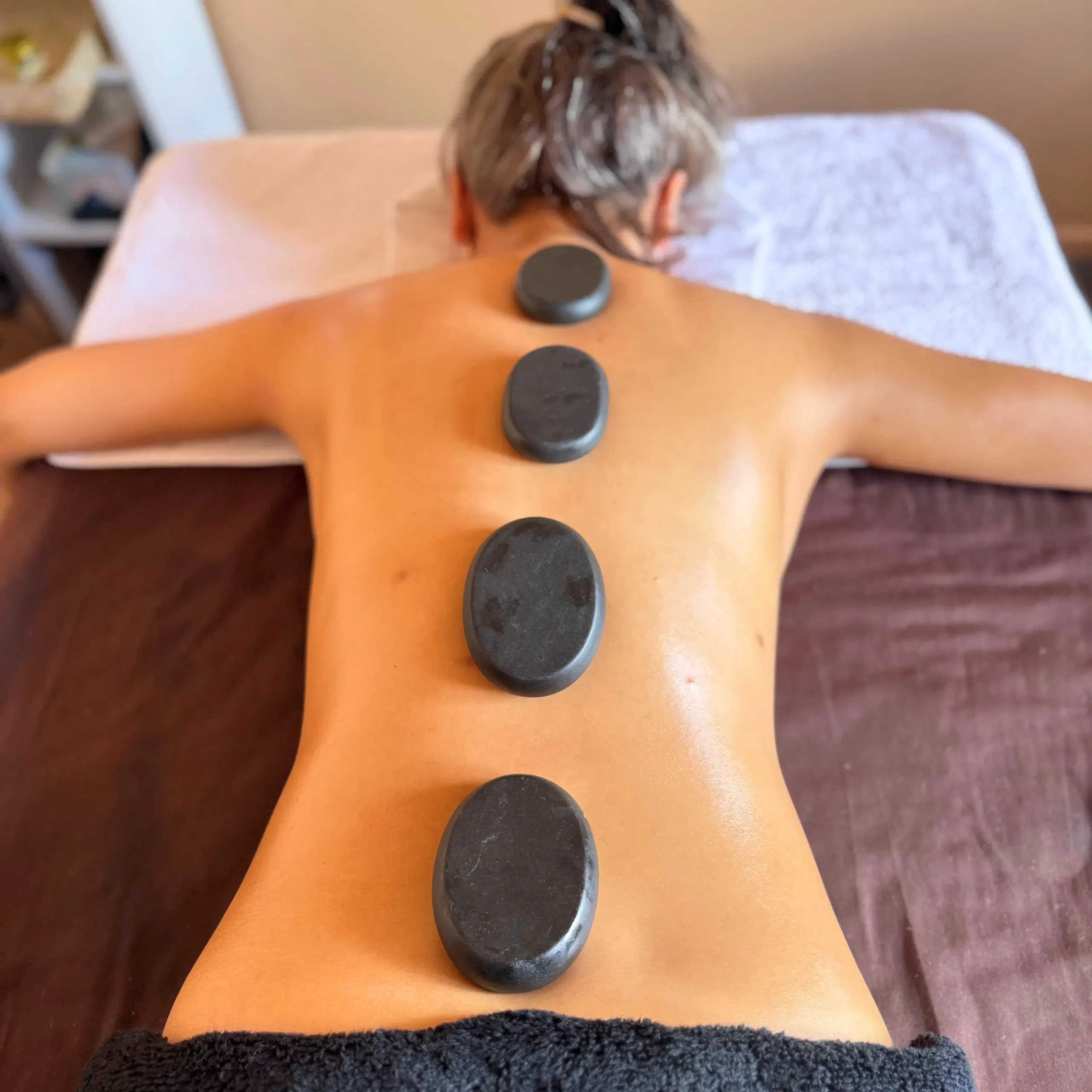 A photo of hot stones on a clients back for a hot stone massage example