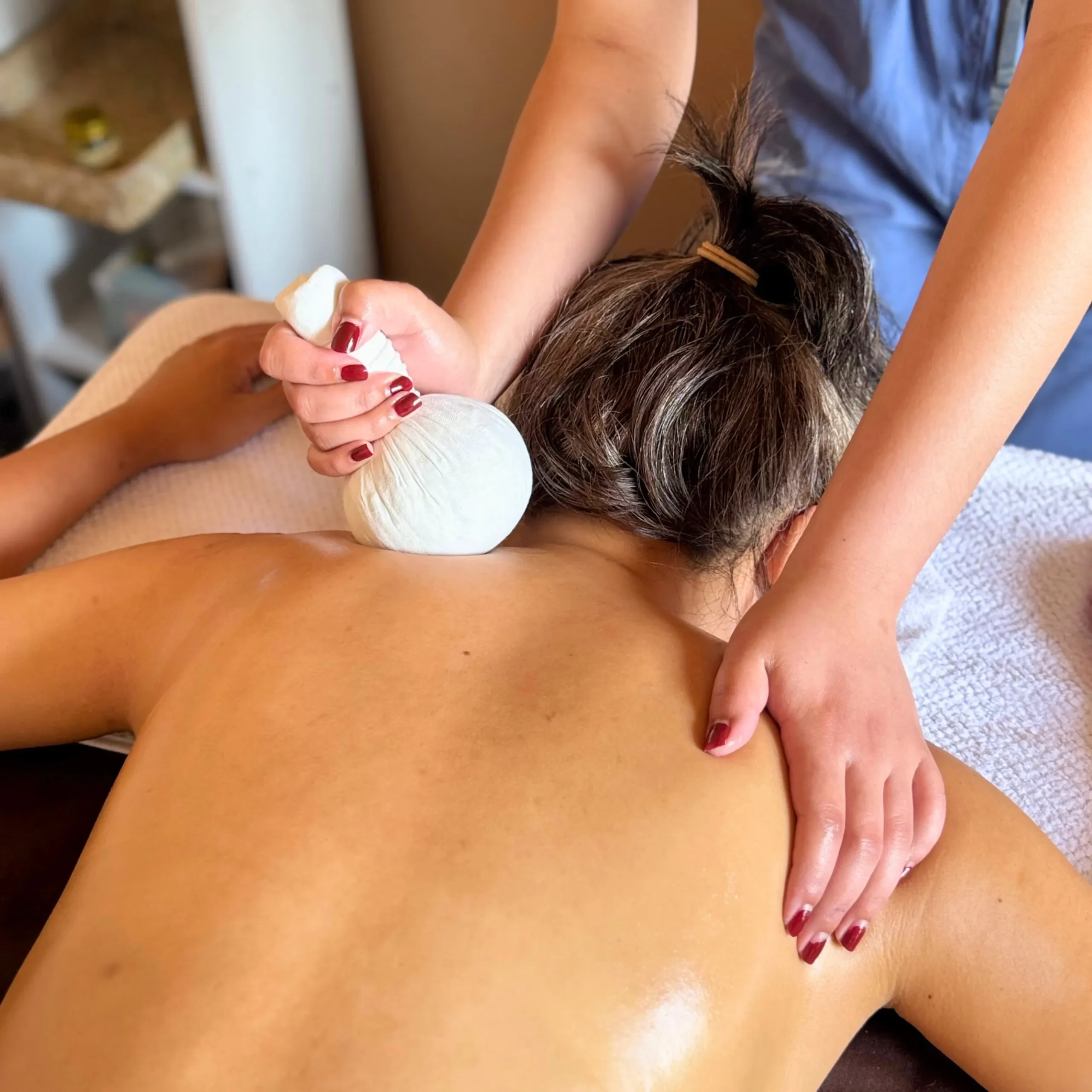 A photo of kitty using the aromatherapy herbal balls on the back of another woman