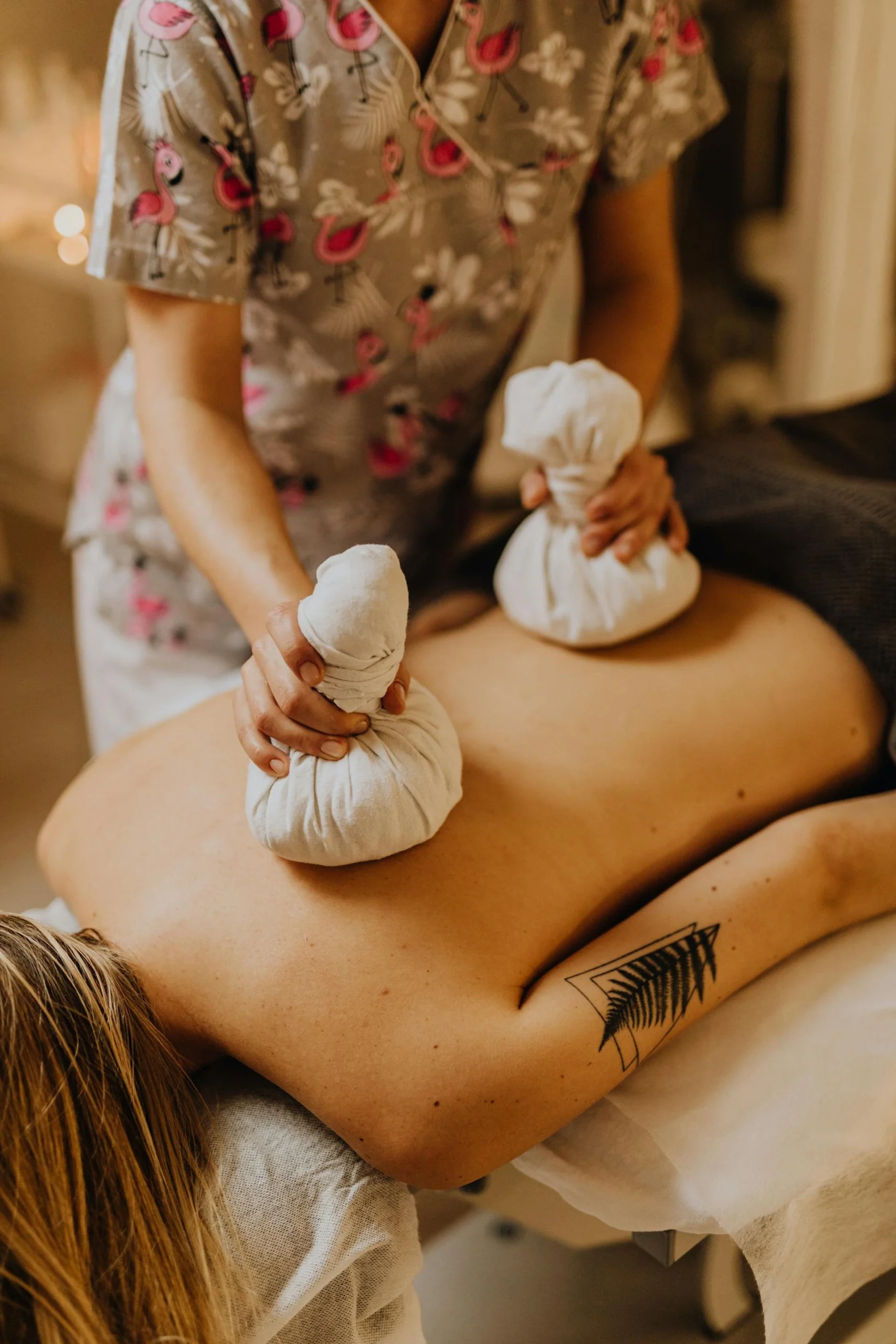 photo of woman giving another woman aromatherapy treatment with the aroma balls on the back